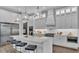 Modern kitchen features a large island, sleek white cabinets, stainless steel appliances, and stylish pendant lighting at 1529 Rio Vista Ter, Parrish, FL 34219