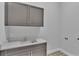 Laundry room with gray cabinets, quartz countertop, and patterned floor at 1529 Rio Vista Ter, Parrish, FL 34219