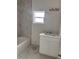 Clean bathroom with white vanity, marble tile, and bathtub at 63 Coxswaine Cir, Placida, FL 33946