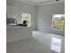 Modern kitchen with white cabinets, marble floors and large windows at 63 Coxswaine Cir, Placida, FL 33946