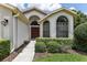 House entrance with arched windows and landscaped walkway at 533 Bent Oak Ct, Spring Hill, FL 34609