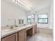 Clean bathroom with double vanity, a bathtub, and plenty of natural light at 533 Bent Oak Ct, Spring Hill, FL 34609