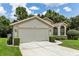 Home's exterior with a two-car garage and lush landscaping at 533 Bent Oak Ct, Spring Hill, FL 34609