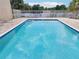 Community pool with patio furniture and lake view at 811 N Keene Rd # V7, Clearwater, FL 33755