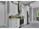 Modern kitchen with white cabinets, stainless steel appliances, and gray backsplash at 111 Long Meadow Ln, Rotonda West, FL 33947