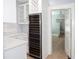 Kitchen area with wine refrigerator, white cabinets, and hallway with view of hanging chandelier at 236 20Th Ave Se, St Petersburg, FL 33705