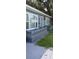 Side view of a blue house with a gray railing, decorative accents, and lush lawn at 7804 Chasco St, Port Richey, FL 34668