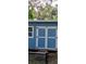 Blue storage shed with double doors and a single window at 7804 Chasco St, Port Richey, FL 34668