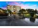 Exterior view of a condo building at dusk with parking lot and landscaping at 6219 Palma Del Mar S Blvd # 301, St Petersburg, FL 33715
