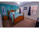 Bedroom with wood bed frame, teal walls, and navy curtains at 3601 57Th Avenue W Dr # 31, Bradenton, FL 34210