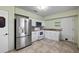 Well-equipped kitchen with stainless steel refrigerator, white cabinets, and tiled backsplash at 1023 Madison St, Largo, FL 33770
