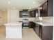 Modern kitchen featuring dark wood cabinets, stainless steel appliances, and a spacious island at 17384 Robinson Ave, Port Charlotte, FL 33948