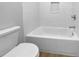 White tiled bathroom with bathtub and toilet at 1340 Redstart Rd, Venice, FL 34293