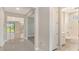 Hallway with tile flooring leads to an open concept living area and a bathroom with tub and shower at 4990 Fairhope Cir, Lakewood Ranch, FL 34211