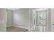 Bright living room with wood-look flooring and light gray paint leads to the tiled foyer with a glass front door at 4990 Fairhope Cir, Lakewood Ranch, FL 34211