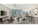Open-concept living area with modern design, large windows offering a view of the backyard, and a breakfast bar at 4990 Fairhope Cir, Lakewood Ranch, FL 34211