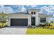 Modern single-story home with dark gray garage door and landscaping at 4845 Carova Way, Lakewood Ranch, FL 34211
