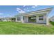 Rear exterior showing a sliding glass door onto the patio and the green lawn at 4910 Carova Way, Lakewood Ranch, FL 34211