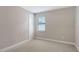 Well-lit bedroom featuring neutral paint, carpet, baseboards, a door and a window with blinds at 4910 Carova Way, Lakewood Ranch, FL 34211