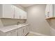 Laundry room features white cabinets, white counter tops and a stainless steel sink at 4910 Carova Way, Lakewood Ranch, FL 34211