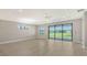 Open-concept living room with ceiling fan, large sliding glass doors, and light wood flooring at 4910 Carova Way, Lakewood Ranch, FL 34211