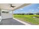 Covered patio with brick pavers and ceiling fan overlooking a lush green lawn and pond at 4910 Carova Way, Lakewood Ranch, FL 34211