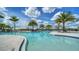 Large pool with palm trees, cabanas, and blue skies overhead at 4910 Carova Way, Lakewood Ranch, FL 34211