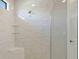 Modern shower with floor-to-ceiling marble-look tiles, glass door, and built-in bench at 4910 Carova Way, Lakewood Ranch, FL 34211