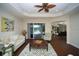 Living room with hardwood floors, sofa, and view of pool at 7280 Verna Bethany Rd, Myakka City, FL 34251