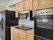 Modern kitchen with black appliances and light wood cabinets at 716 Fox Hills Dr, Sun City Center, FL 33573