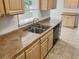 Kitchen features light wood cabinets, double sink, and tile flooring at 716 Fox Hills Dr, Sun City Center, FL 33573