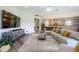 Open living room with sectional sofa, large TV, and view into kitchen at 291 Mossy River Ct, Brandon, FL 33511