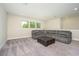 Spacious bonus room with gray sectional sofa and carpet flooring at 291 Mossy River Ct, Brandon, FL 33511