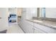 Bathroom with granite countertop, gray cabinets, and a view of bedroom at 291 Mossy River Ct, Brandon, FL 33511