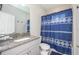 Bathroom with granite countertop, gray cabinets, and a blue shower curtain at 291 Mossy River Ct, Brandon, FL 33511