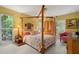 Bedroom with canopy bed, floral bedding, and access to garden at 200 Colony Point S Rd, St Petersburg, FL 33705