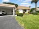 Single-story home with carport, manicured lawn, and palm trees at 2413 Riverbluff Pkwy # V-231, Sarasota, FL 34231