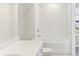 Clean bathroom with tub, toilet and white tiled walls at 7659 Momentum Pkwy, Wesley Chapel, FL 33545