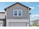 Modern townhome exterior featuring gray siding and a two-car garage at 7659 Momentum Pkwy, Wesley Chapel, FL 33545