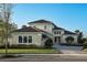 Two-story home with a light beige exterior and a paver driveway at 8900 Bernini Pl, Sarasota, FL 34240