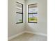 Bright bedroom features light walls, tiled floor, and windows offering neighborhood views at 18324 Rockport Pl, Lakewood Ranch, FL 34211
