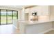 Modern kitchen features white cabinets, quartz countertops, stainless steel appliances and sliding door to backyard at 18324 Rockport Pl, Lakewood Ranch, FL 34211