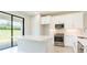 Contemporary kitchen boasts white cabinetry, stainless steel appliances, and an island with breakfast bar seating at 18324 Rockport Pl, Lakewood Ranch, FL 34211