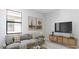 Cozy living room with grey sofa, media console and natural accents at 18324 Rockport Pl, Lakewood Ranch, FL 34211