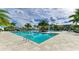 Luxury swimming pool featuring turquoise water, palm trees, and comfortable lounge seating under a bright sky at 18324 Rockport Pl, Lakewood Ranch, FL 34211