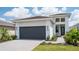 Modern one-story home with gray garage door and walkway at 18324 Rockport Pl, Lakewood Ranch, FL 34211