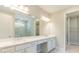 Double vanity bathroom with a large mirror and access to closet at 18324 Rockport Pl, Lakewood Ranch, FL 34211