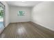 Simple bedroom with wood-look floors and exterior access at 790 Harvard St, Englewood, FL 34223