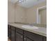 Clean bathroom with dark vanity, single sink, and a large mirror at 12302 Fairlawn Dr, Riverview, FL 33579