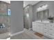 Modern bathroom with white vanity, walk-in shower, and gray tile at 82 Fairway Rd, Rotonda West, FL 33947